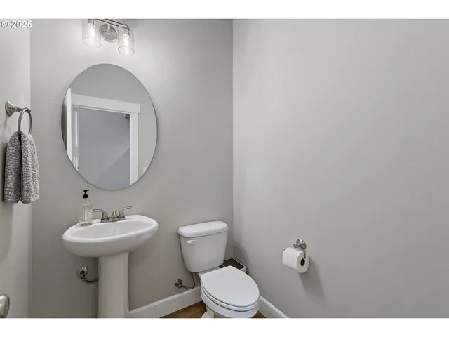 a bathroom with a toilet a sink and mirror