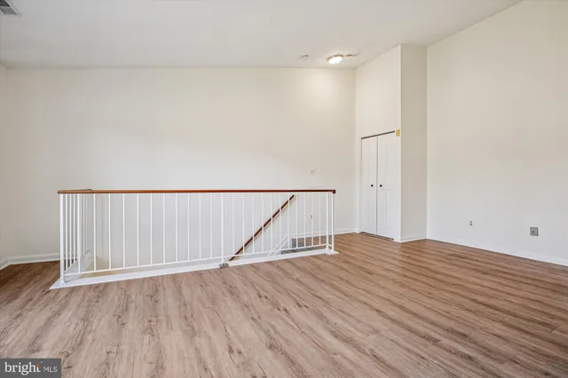 a view of empty room with wooden floor