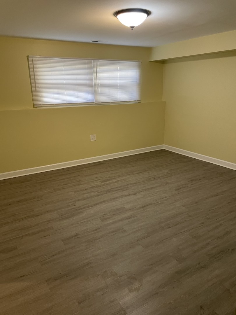 6830 Valley View Road Hanover Park, IL 60133 - Photo 12 of 14 a view of an empty room with window and wooden floor