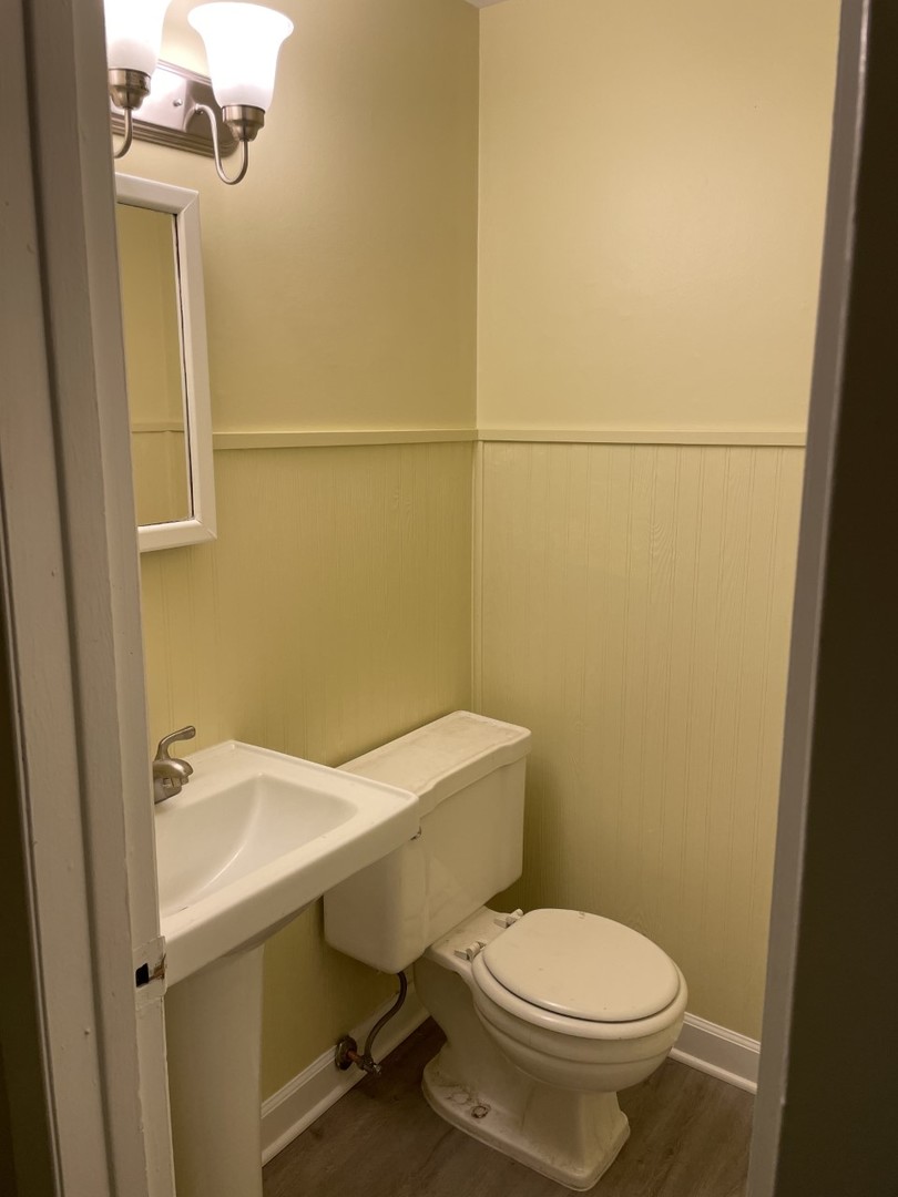 6830 Valley View Road Hanover Park, IL 60133 - Photo 10 of 14 a white toilet sitting next to a white sink and vanity