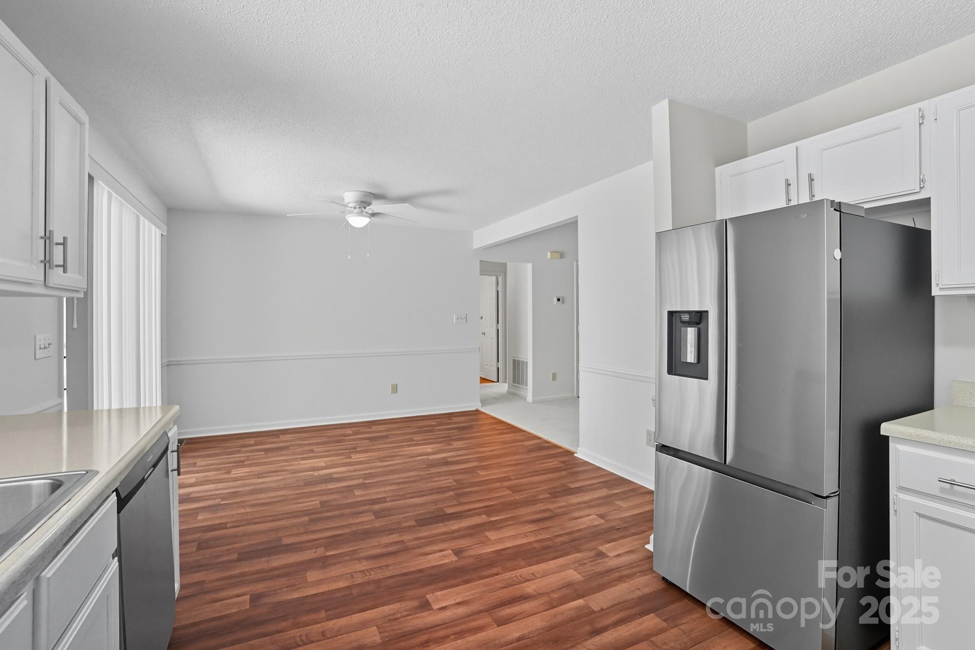 803 Victorian Lane Monroe, NC 28112 - Photo 8 of 46 a view of a kitchen with a refrigerator and wooden floor