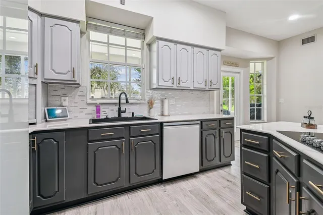 a kitchen with stainless steel appliances granite countertop a sink a stove cabinets counter space and a window