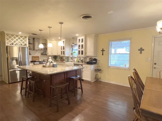 a kitchen with a dining table chairs and refrigerator