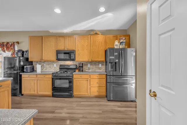 a kitchen with a table chairs sink refrigerator and microwave