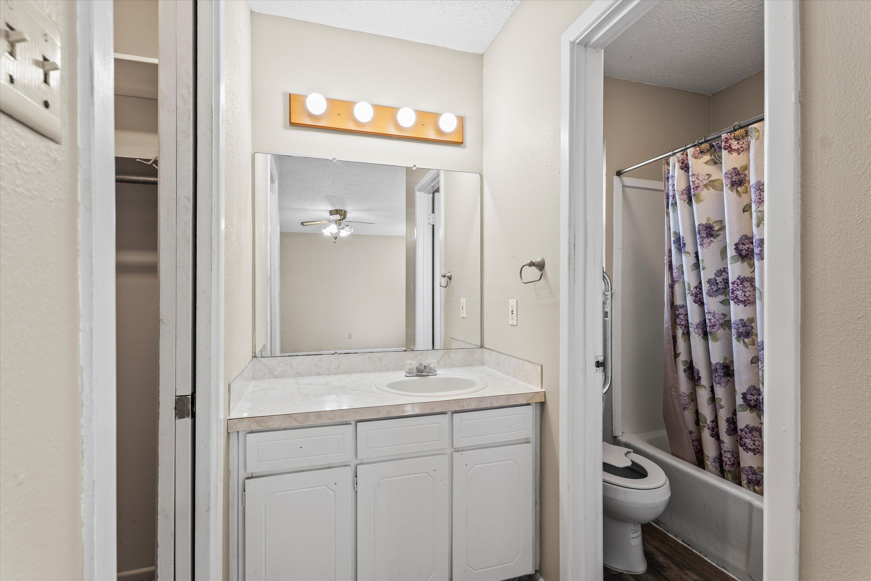 4520 54th Street Lubbock, TX 79414 - Photo 16 of 32 a bathroom with a sink a toilet and shower