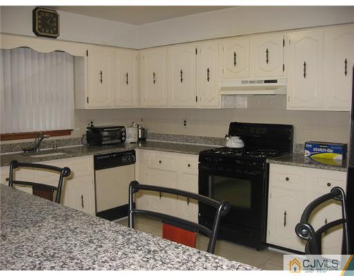 9 Birch Road Edison, NJ 08817 - Photo 7 of 10 a kitchen with granite countertop white cabinets and black appliances