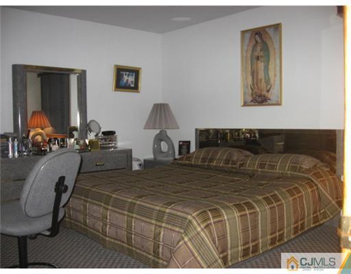 9 Birch Road Edison, NJ 08817 - Photo 8 of 10 a bedroom with a bed and glass windows