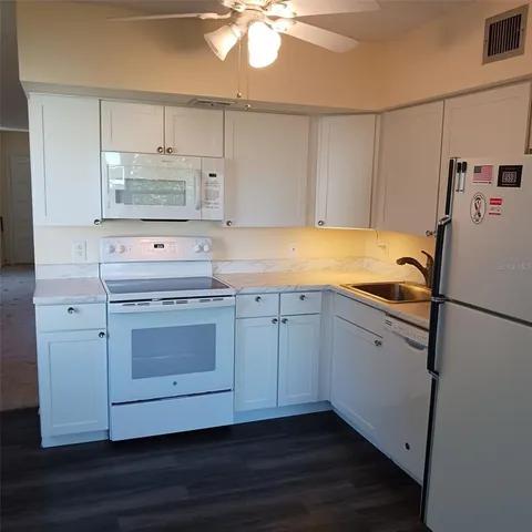 a kitchen with cabinets appliances a sink and a counter space