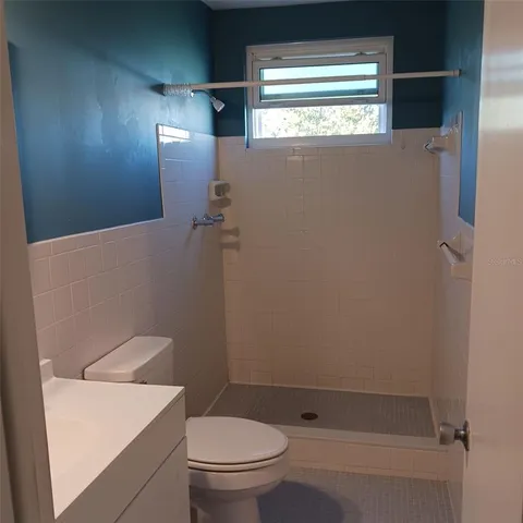 a bathroom with a toilet and a shower