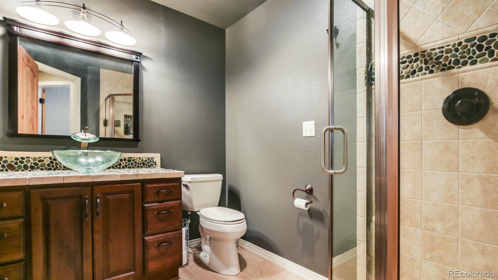 50 South Pine Road Golden, CO 80401 - Photo 33 of 35 a bathroom with a granite countertop sink a toilet mirror and shower