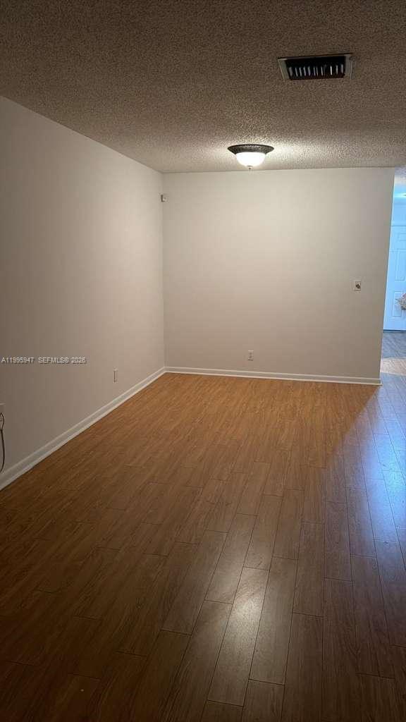 13731 Flora Place, Unit A Delray Beach, FL 33484 - Photo 11 of 21 an empty room with wooden floor