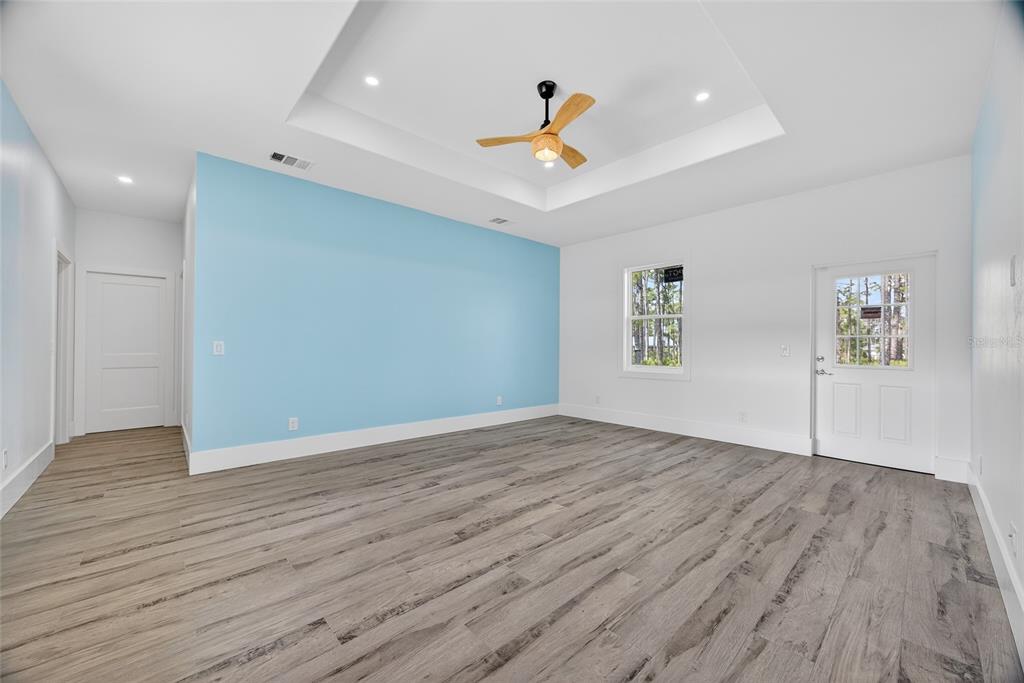 14192 Riseley Avenue Port Charlotte, FL 33953 - Photo 15 of 54 a view of an empty room with wooden floor and a ceiling fan
