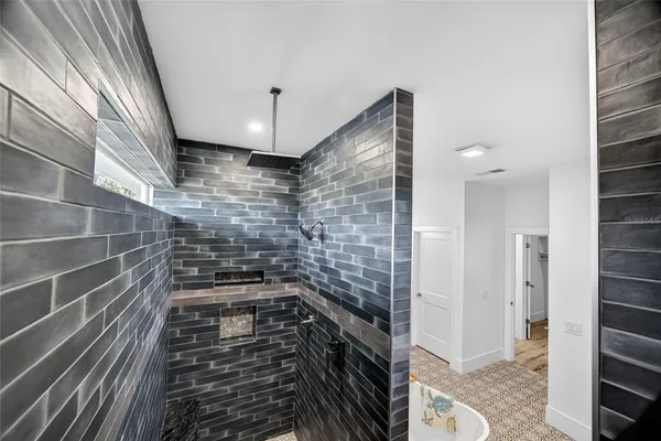 a bathroom with a shower a mirror and a sink