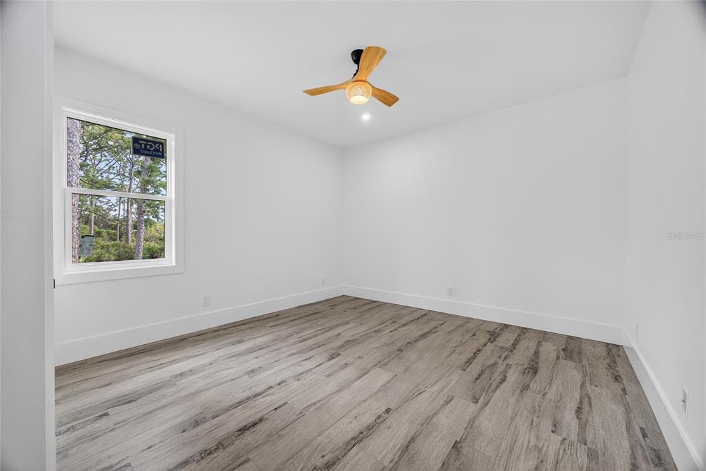 14192 Riseley Avenue Port Charlotte, FL 33953 - Photo 25 of 54 wooden floor in an empty room with a window