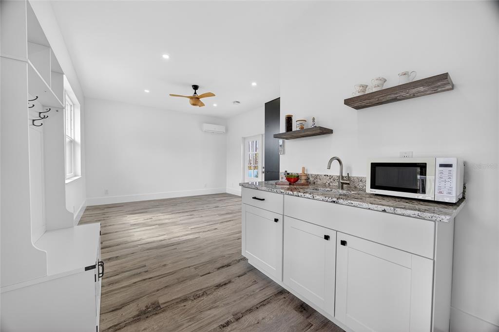 14192 Riseley Avenue Port Charlotte, FL 33953 - Photo 31 of 54 a kitchen with stainless steel appliances granite countertop a sink and a stove top oven with wooden floor
