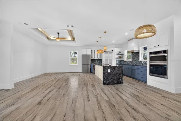 a large kitchen with stainless steel appliances granite countertop a large counter top and wooden floors