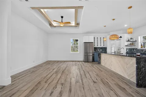 a view of kitchen with stainless steel appliances granite countertop a refrigerator a oven a sink and a wooden floors