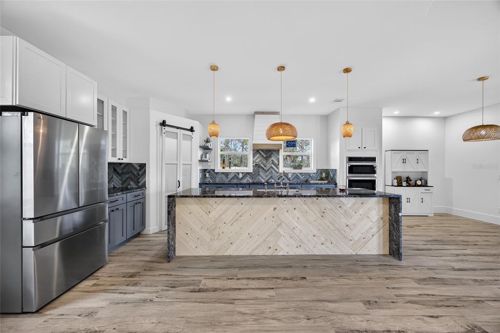 14192 Riseley Avenue Port Charlotte, FL 33953 - Photo 8 of 54 a view of kitchen with stainless steel appliances granite countertop a refrigerator a oven a sink and a wooden floors