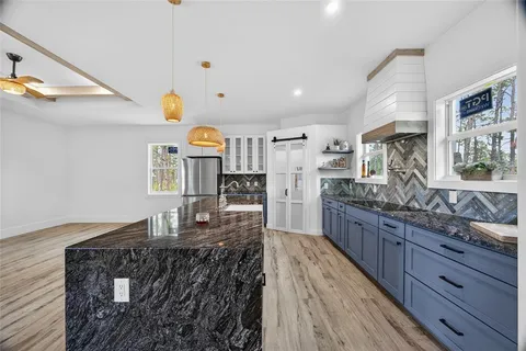 a bathroom with a granite countertop sink and a window