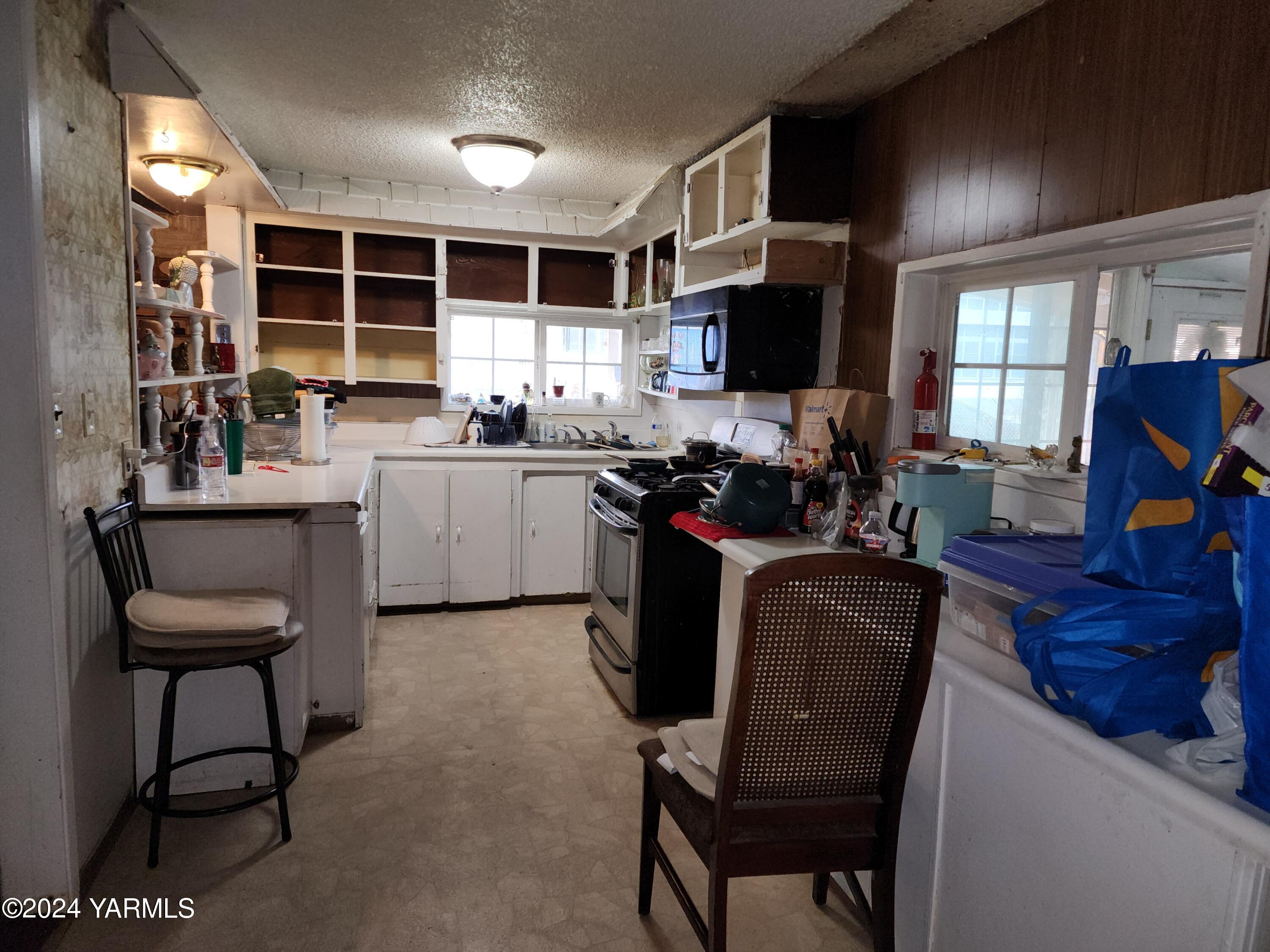 36 East 3rd Avenue Toppenish, WA 98948 - Photo 18 of 20 a kitchen with kitchen island a dining table chairs and a refrigerator