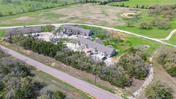 an aerial view of a house with a yard and lake view in back