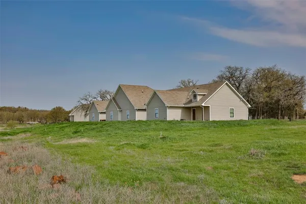 a view of a big yard with a house in the background