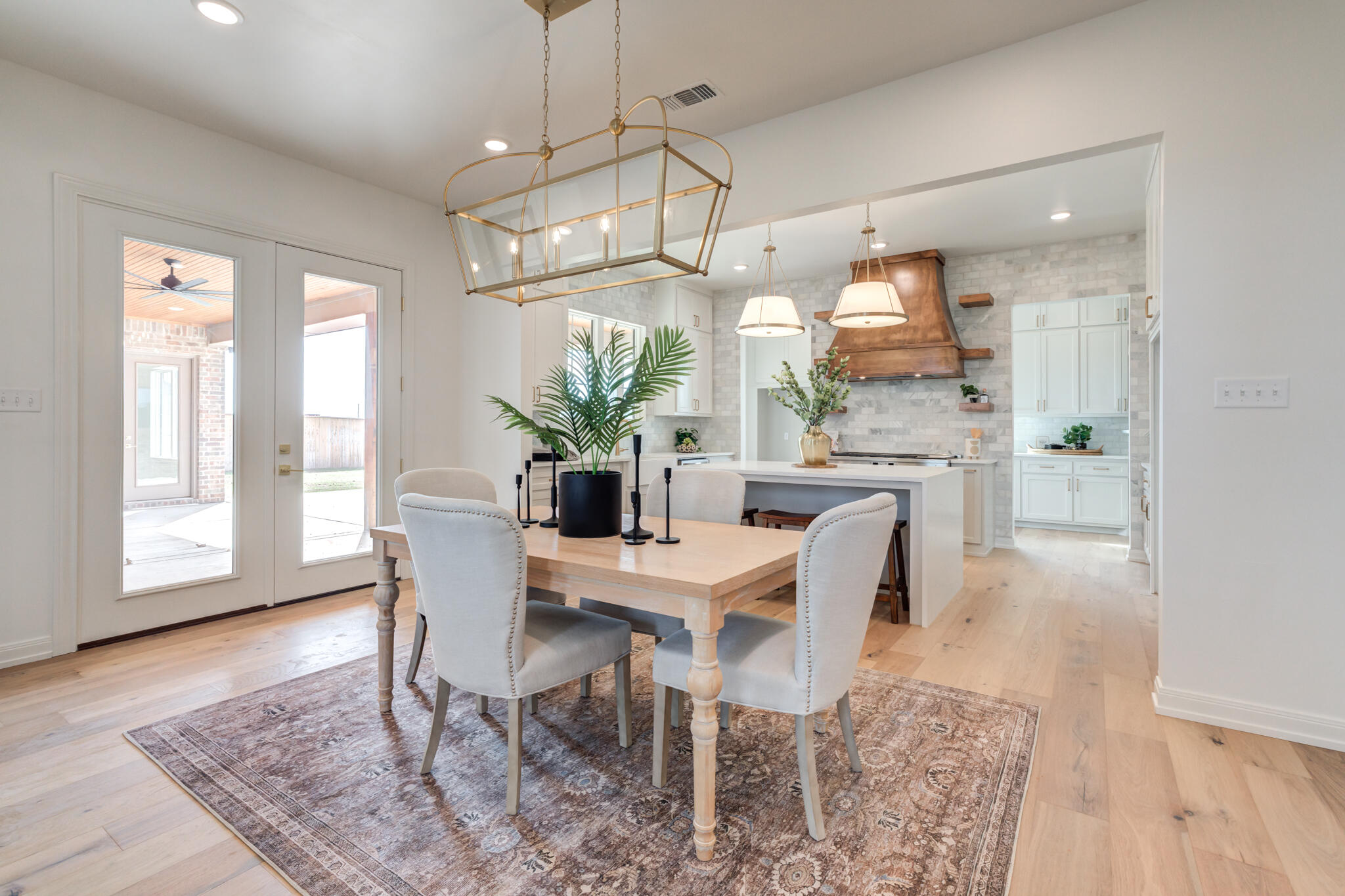 5309 County Road 7670 Lubbock, TX 79424 - Photo 11 of 57 a dining room with furniture a chandelier and wooden floor