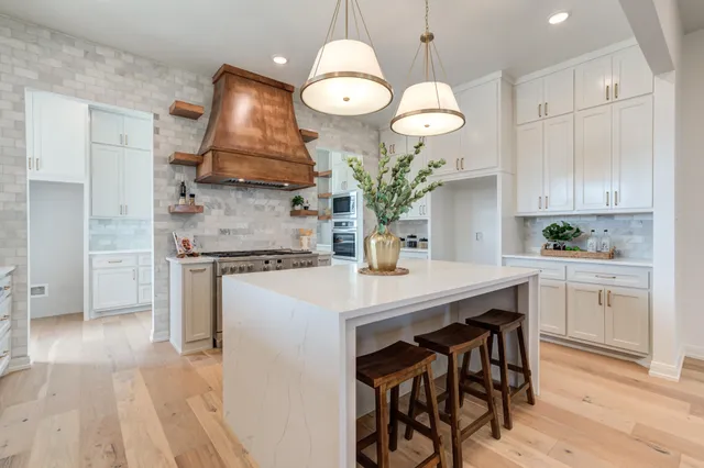 a kitchen with granite countertop a white stove top oven and cabinets