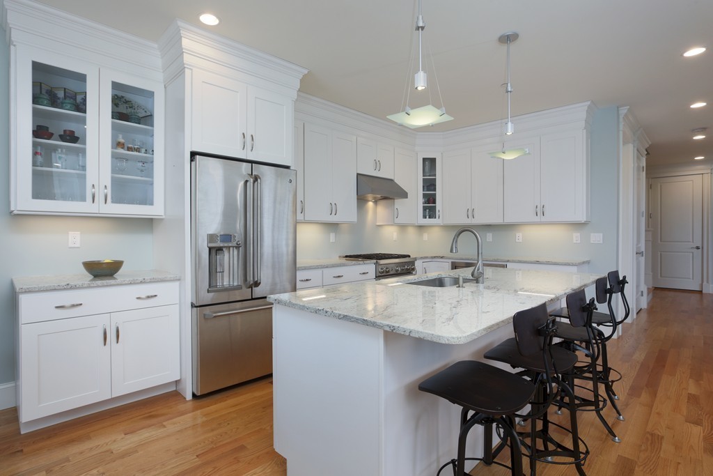 23 Lillian Way, Unit 28 Wayland, MA 01778 - Photo 1 of 16 a kitchen with refrigerator a sink and chairs