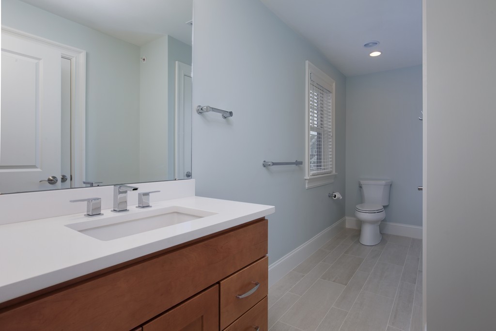23 Lillian Way, Unit 28 Wayland, MA 01778 - Photo 11 of 16 a bathroom with a sink a toilet and a mirror