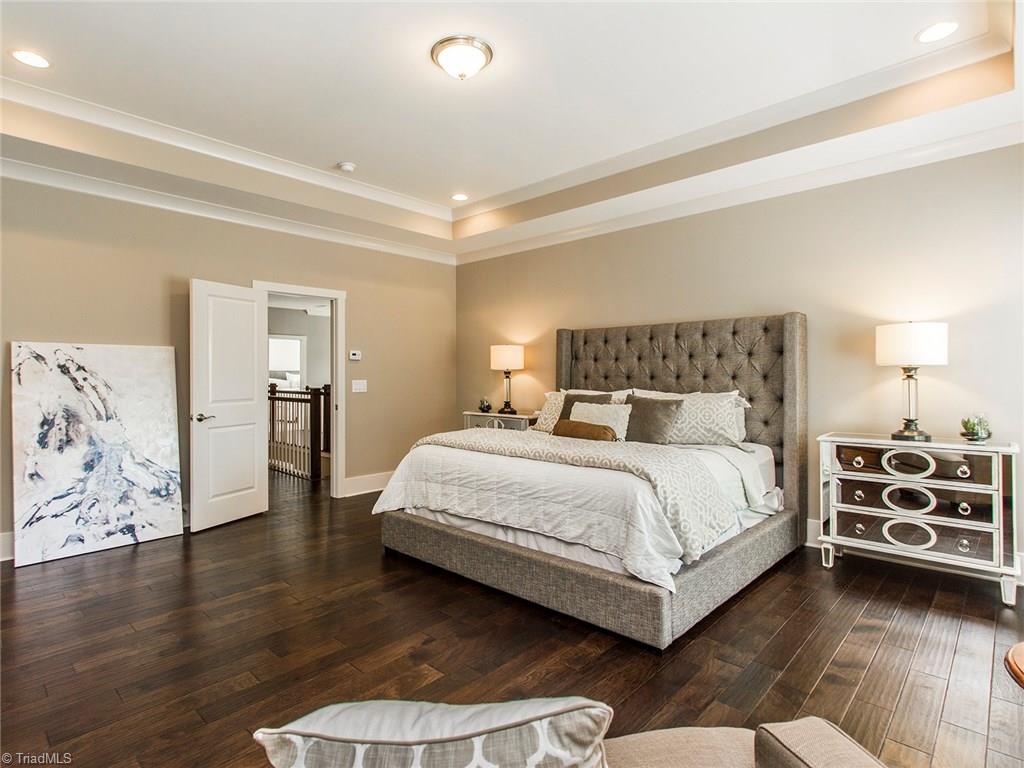 6807 Koala Drive Oak Ridge, NC 27310 - Photo 18 of 28 Tray ceilings, recessed lighting, continued wide plank hardwoods and SPACE abound in the stately master bedroom.