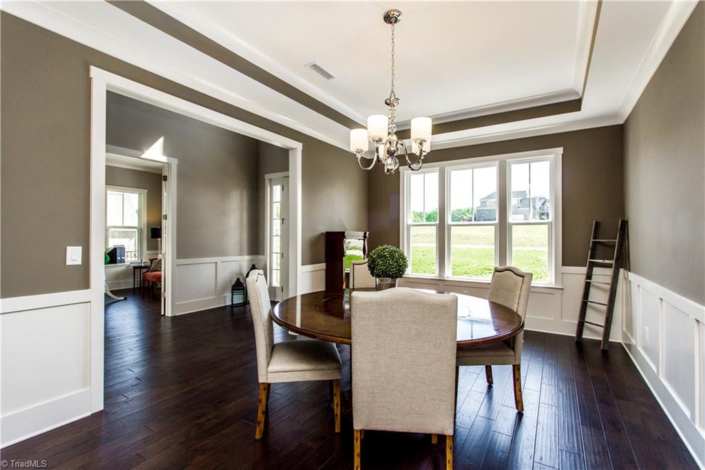 6807 Koala Drive Oak Ridge, NC 27310 - Photo 4 of 28 Romantic dining room with tray ceilings and chair rail molding throughout.