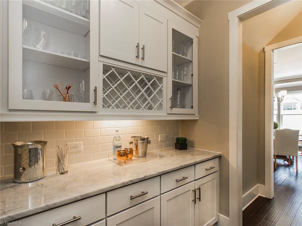 6807 Koala Drive Oak Ridge, NC 27310 - Photo 7 of 28 Butlers Pantry with marble counters and subway tile connect the dining room and kitchen during entertaining. Also adds tons of great storage.