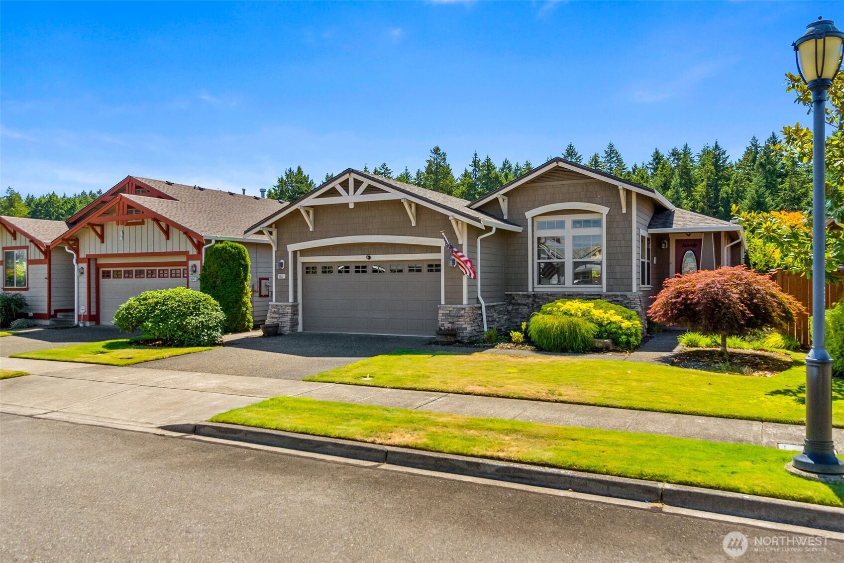 8650 Bainbridge Loop Northeast Lacey, WA 98516 - Photo 3 of 34 a front view of a house with a yard and garage