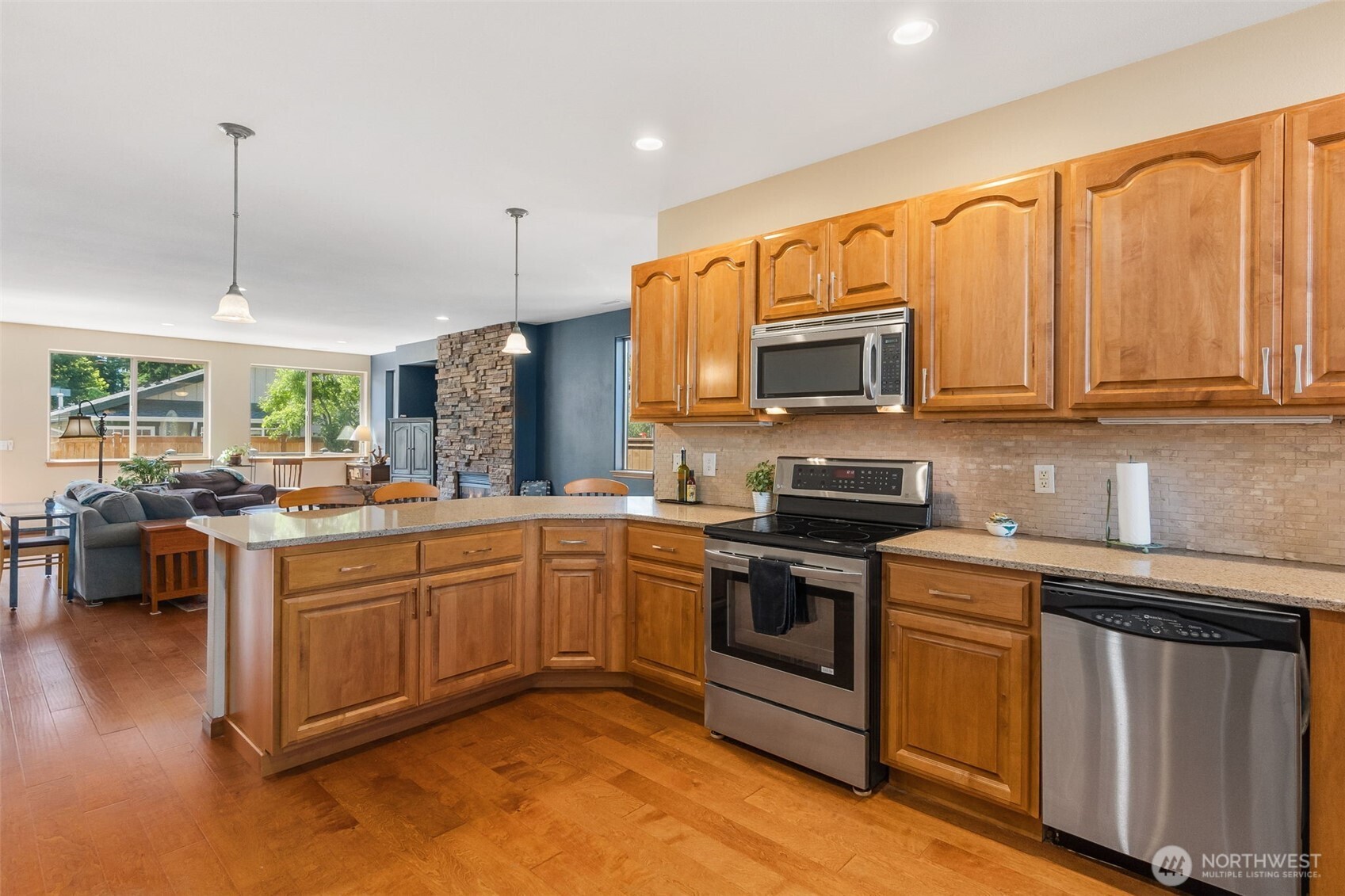8650 Bainbridge Loop Northeast Lacey, WA 98516 - Photo 9 of 34 a kitchen with stainless steel appliances granite countertop wooden cabinets a sink dishwasher a stove and a refrigerator with wooden floor