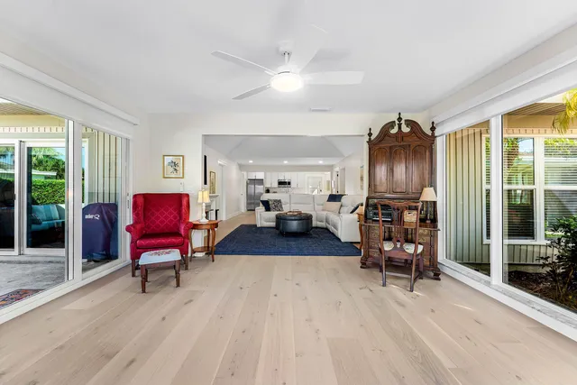 a living room with furniture a large window and glass door