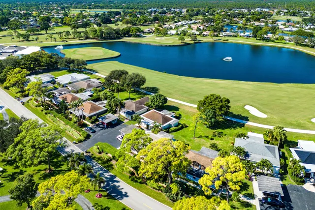 an aerial view of a residential houses with outdoor space and trees all around