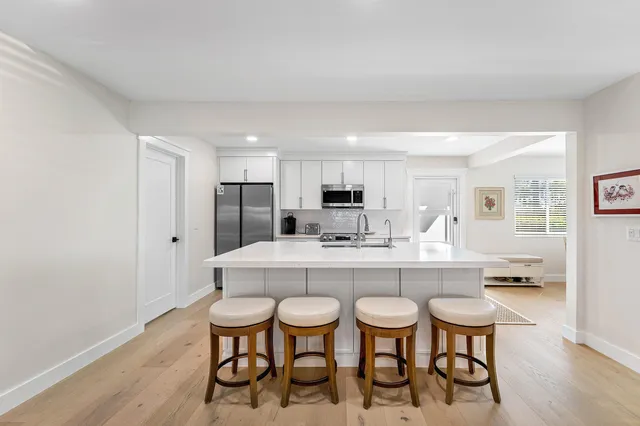a large white kitchen with a table and chairs