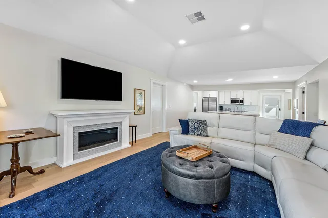 a living room with furniture a fireplace and a flat screen tv