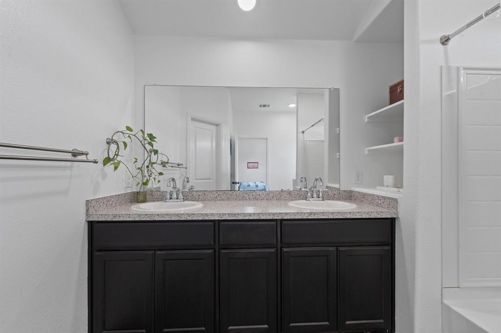 4600 Fringetree Way Crowley, TX 76036 - Photo 22 of 40 Dual vanity with dark wood-finish cabinetry and light speckled countertops