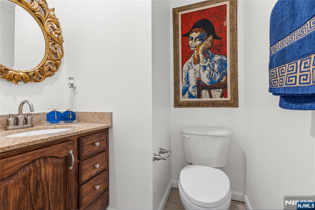 73 Big Piece Road Fairfield, NJ 07004 - Photo 16 of 45 a bathroom with a toilet a sink and a mirror