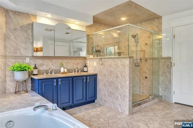 a bathroom with a tub shower sink and mirror