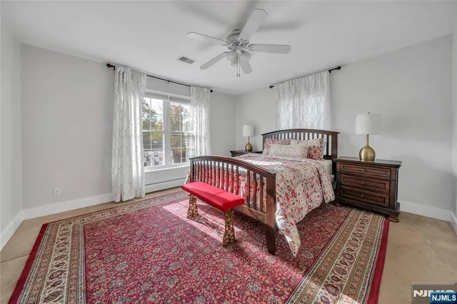 a bed sitting in a spacious bedroom next to a window