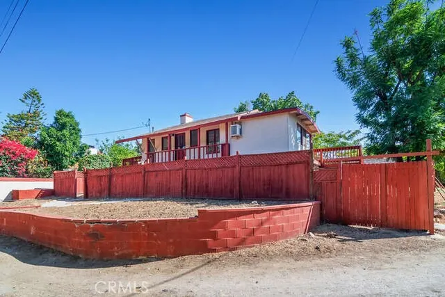 a view of a backyard with a large tree and wooden fence