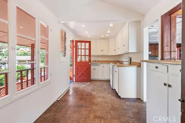 a kitchen with cabinets appliances and a wooden floor