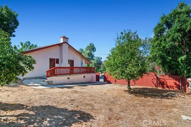 a view of a house with a yard and large tree