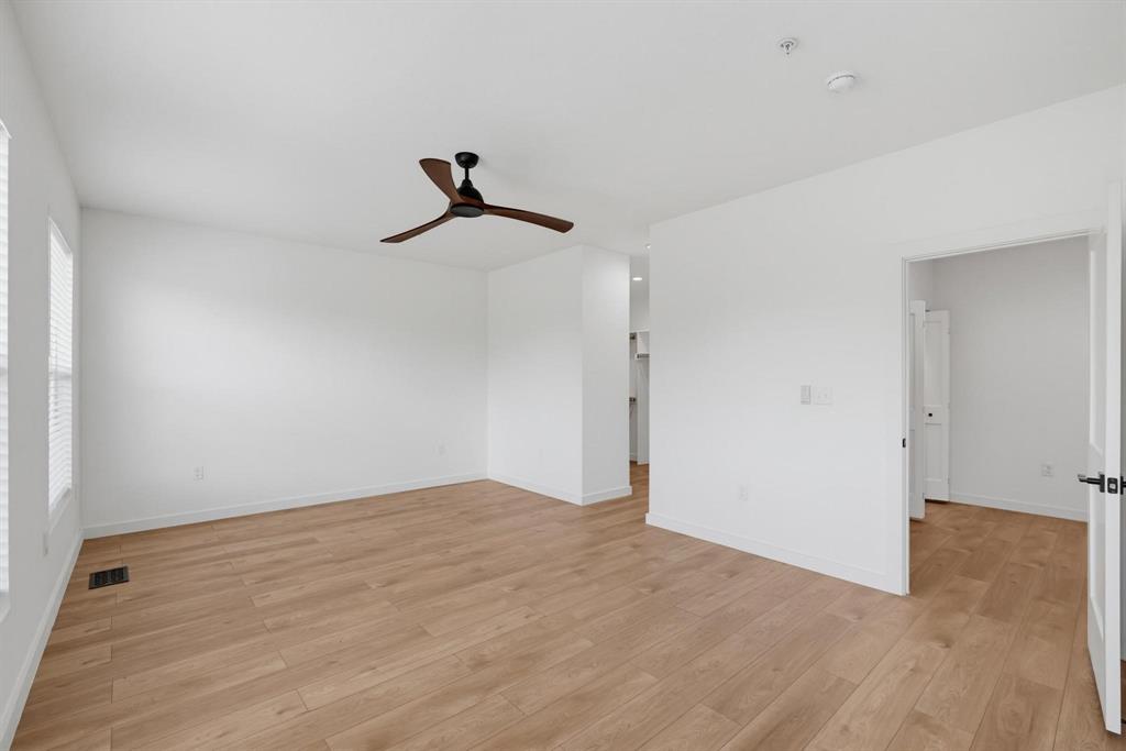504 South O Connor Road Irving, TX 75060 - Photo 13 of 23 Spacious room featuring wood-finish flooring, crisp white walls, and a contemporary ceiling fan