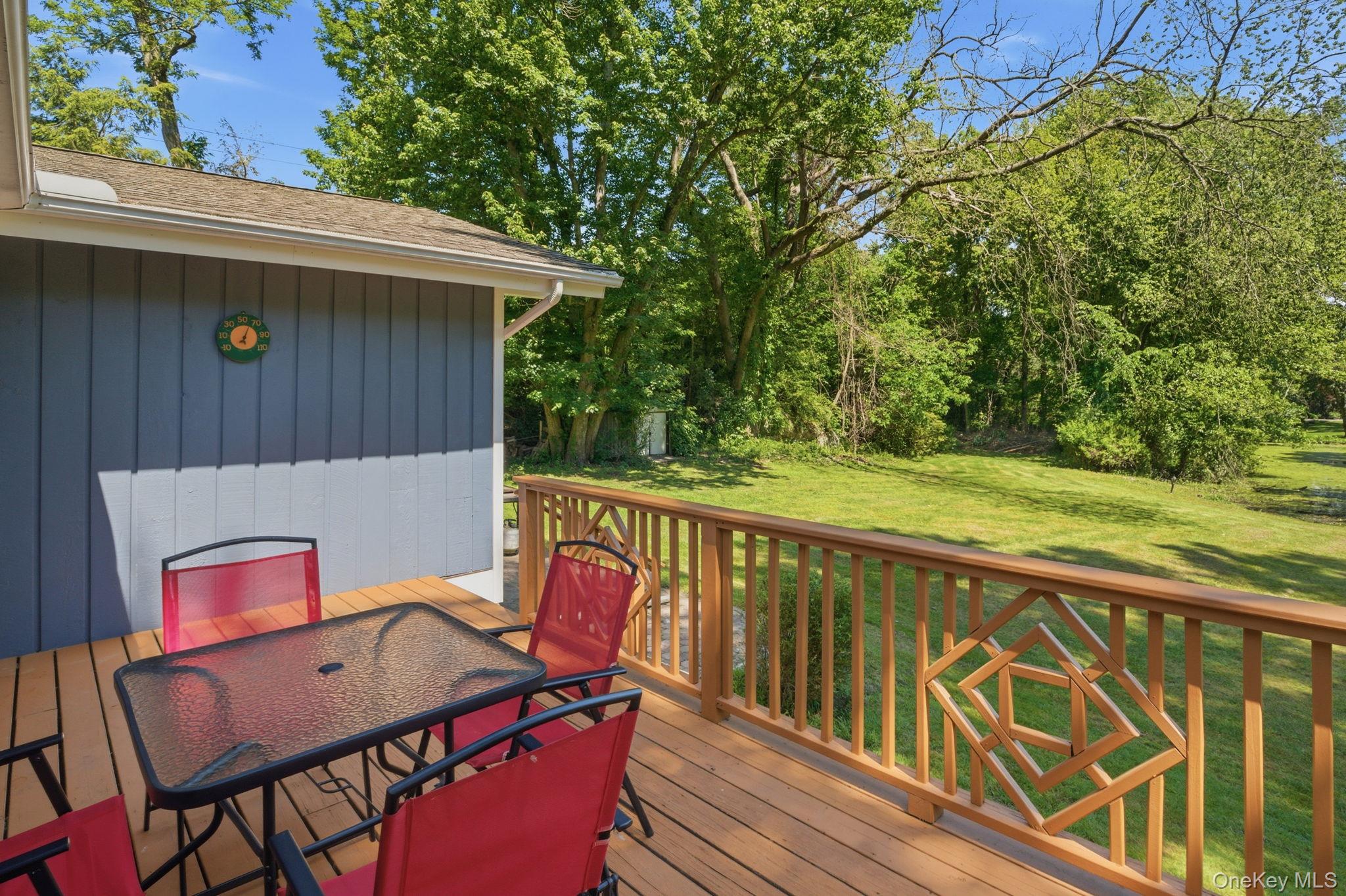 35 Deans Bridge Road Somers, NY 10589 - Photo 24 of 49 The deck looks out over a private, level backyard that rolls toward the trees, with the pond just beyond.