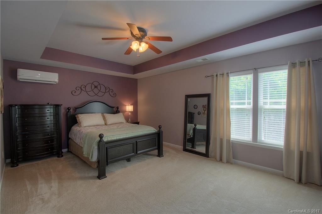 8813 Washam Potts Road Cornelius, NC 28031 - Photo 14 of 24 a spacious bedroom with a bed and a chandelier