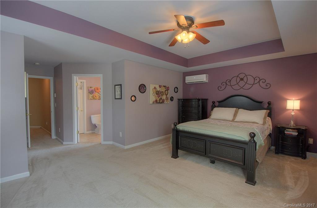 8813 Washam Potts Road Cornelius, NC 28031 - Photo 15 of 24 a bedroom with a bed and a chandelier